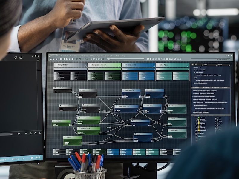Close up of data center programmers using PC to visualize AI neural networks Close up of data center programmers using PC to visualize artificial intelligence neural networks. Server farm IT experts looking at monitor, working together to oversee AI systems